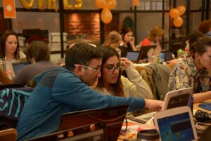 Estudantes adultos estudando em grupo e recebendo orientação durante curso de idiomas